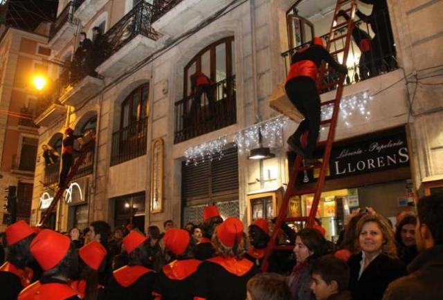 En muchos pueblos, los ayudantes de los Reyes (los "negres") trepan a las casas a repartir regalos tras la cabalgata